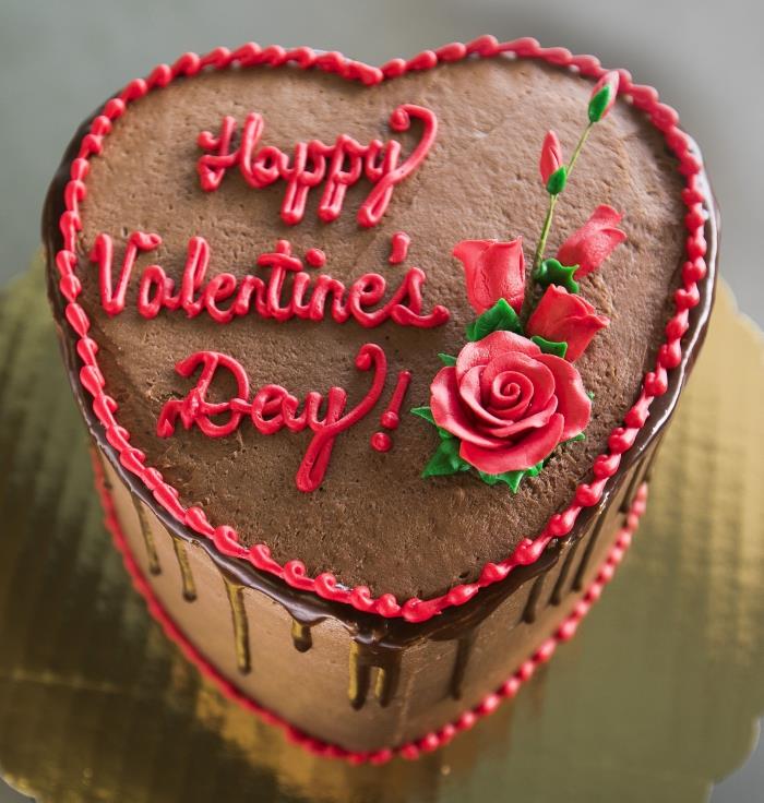 Sevgililer Günü dekorasyon ve küçük kırmızı çiçekler ile karamelli ve bitter çikolatalı kalp pasta örneği