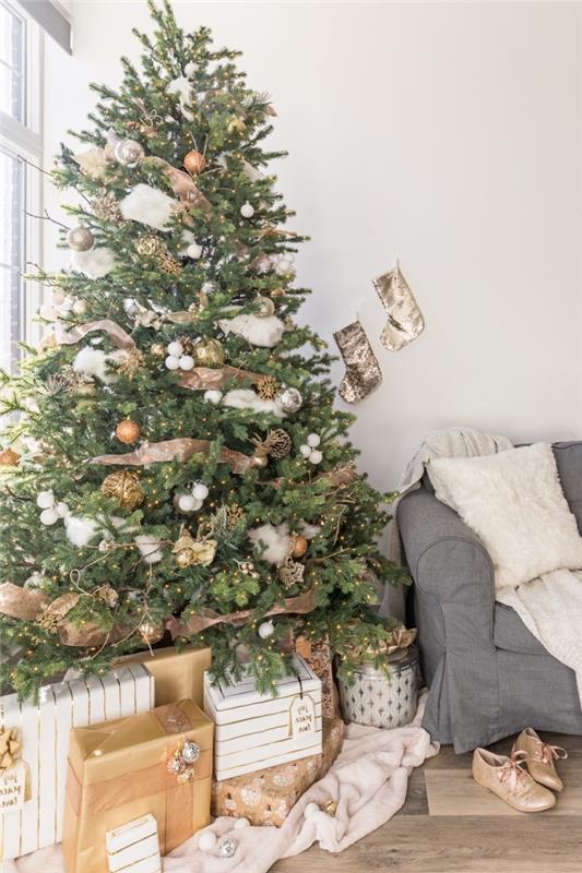 gri mobilyalar ve ahşap zeminler ile beyaz bir oturma odasında minimalist iç tasarım ve koza, altın ve beyaz Noel ağacı dekorasyonu