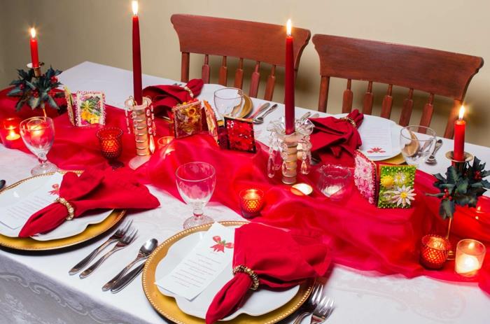 kırmızı tül masa örtüsü, kırmızı mumlar, katlanmış kırmızı tekstil peçeteler, küçük mumluklar, şenlikli Noel dekorasyonu