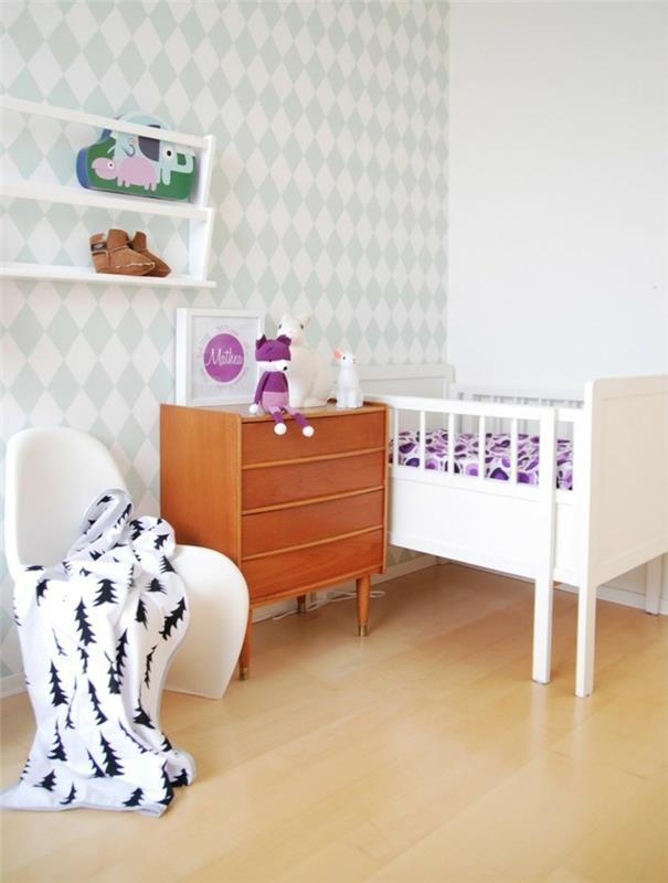 siena balta ir pastelinė mėlyna, kūdikio lovelė rožinės spalvos, šviesiai mediniai baldai, baltos lentynos, smėlio-geltonos spalvos laminatas