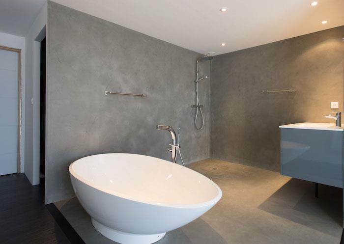İtalyan duşu ve bağımsız küveti olan açık banyo duvarları için mumlu beton sıva