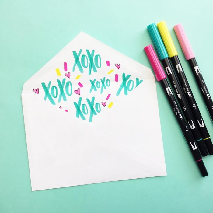 çeşitli renklerde kalemlerle yapılmış çizimler ve kelimelerle beyaz bir zarfın nasıl özelleştirileceğine dair fikir
