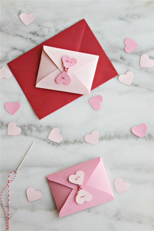kolay origami, mermer desenli yüzeyde küçük renkli kağıt zarflar, kağıttan hediye yapmak için manuel aktivite