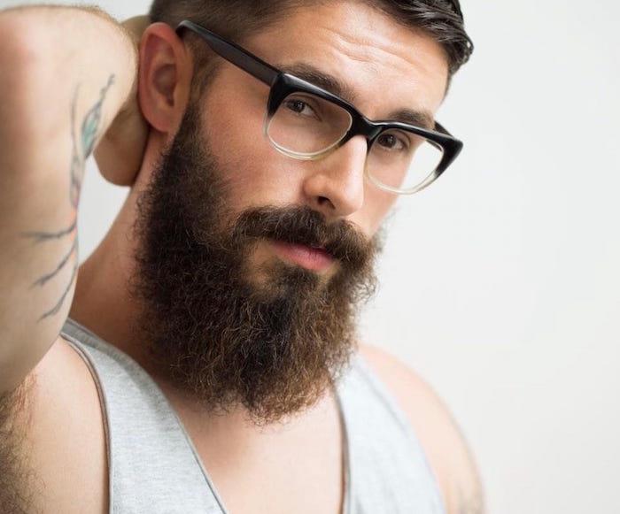 sakallı bir adam modaya uygun hipster gözlüklerini düzelt