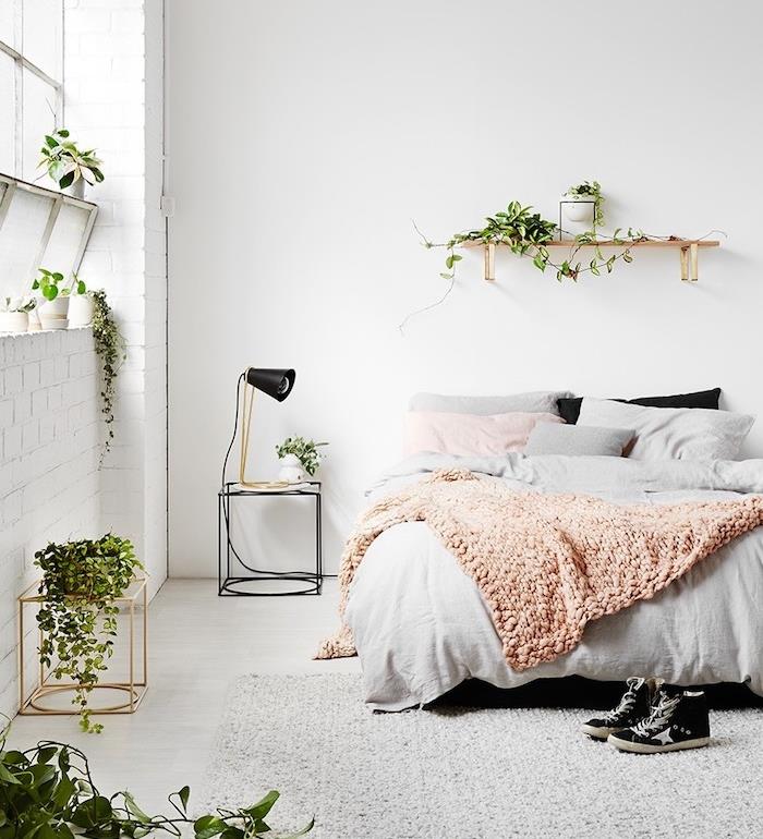 Skandinavska dekoracija spalnice s kokoniranjem z vzorcem džungle, ki so jo predstavile zelene rastline, siva preproga, rožnato in sivo posteljnina, roza, siva in bela dekoracija spalnice