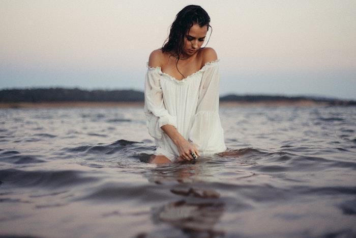 Lepa ženska, ki se potaplja v morje umetniška fotografija boemska bela obleka