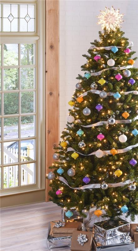 Orijinal bir Noel ağacı için hangi dekorasyon teması, gümüş kurdele ve farklı renklerde toplarla süslenmiş doğal Noel ağacı görüntüsü