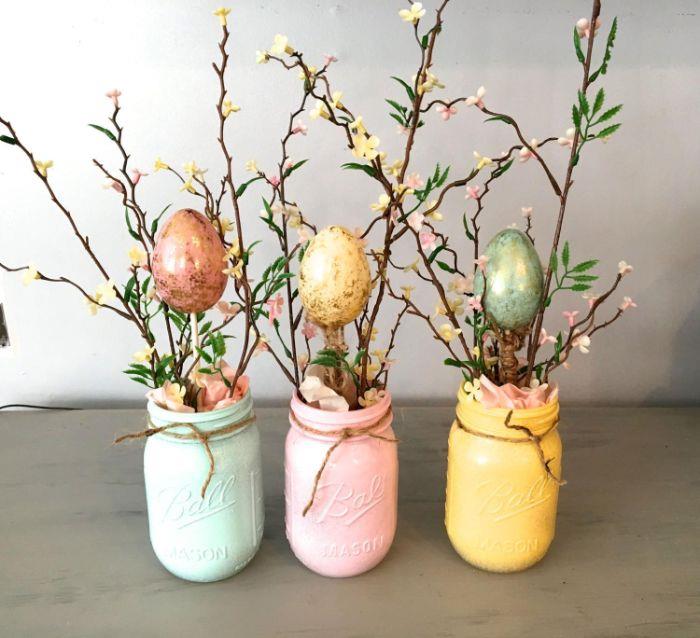primer velikonočni lonci z ročno dejavnostjo, prebarvani s pisano barvo s cvetočimi vejami in barvnimi jajci v papirju