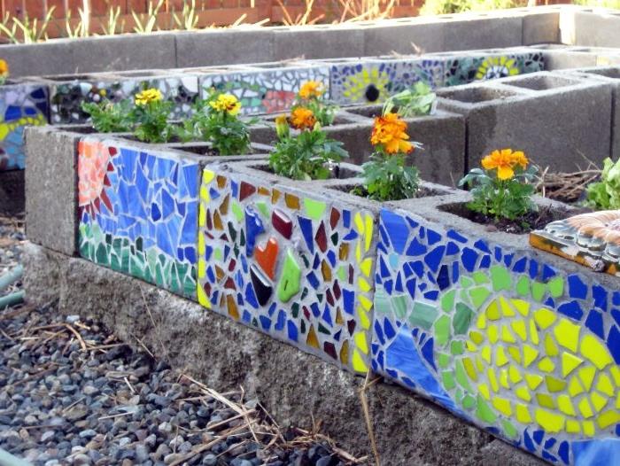 idea betonski bloki, okrašeni s pisanim mozaikom s cvetjem, posajenim v notranjosti, izvirna vrtna dekoracija
