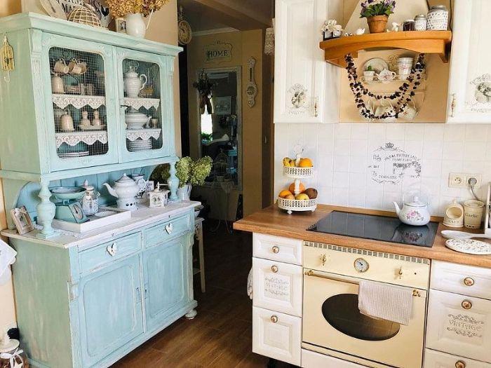 stara podeželska kuhinja s patiniranim modrim predalnikom bela kuhinjska osnova omara vintage izpostavljeno posodo