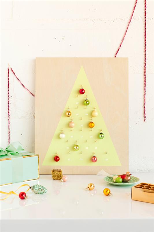 Kalėdų eglutė „pasidaryk pats“ advento kalendorius, nupieštas ant medinio padėklo su spalvotų Kalėdų kamuoliukų puošmena