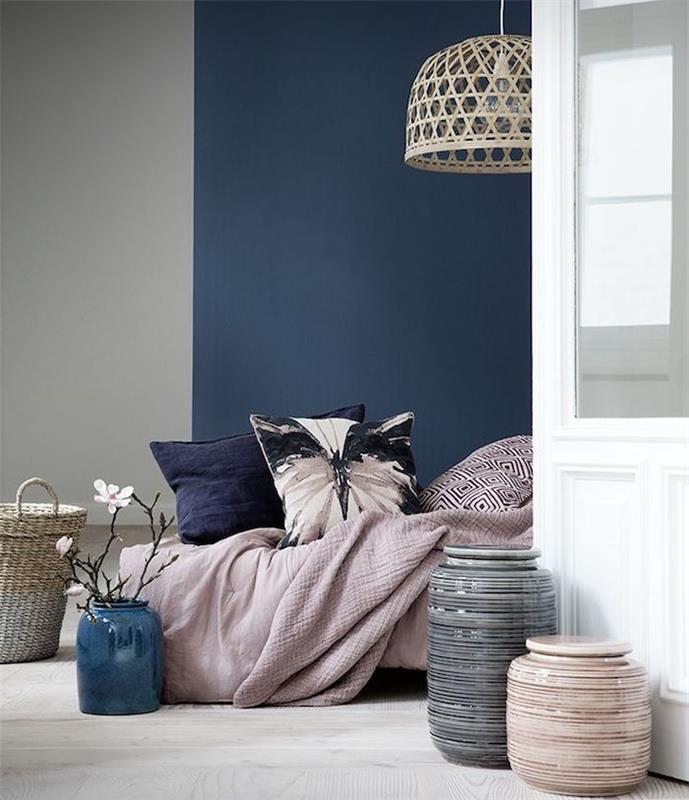 inci grisi boyalı duvar ve koyu mavi boyalı duvar, pembe keten ve dekoratif minderli yatak, dekoratif vazolar egzotik süspansiyon
