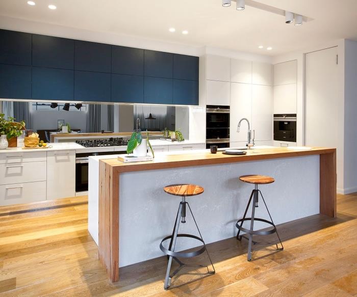 deniz mavisi yüksek mutfak dolapları ile beyaz mobilyalı modern mutfak dekoru, beyaz ve ahşap adalı bir mutfak örneği