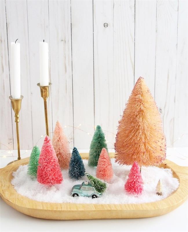 kendin için bir merkez oluştur, kendin yapmak için Noel dekorasyonu, yapay kar ve renkli mini ağaç figürleri ile ahşap tepsi, beyaz mumlarla altın mumlar