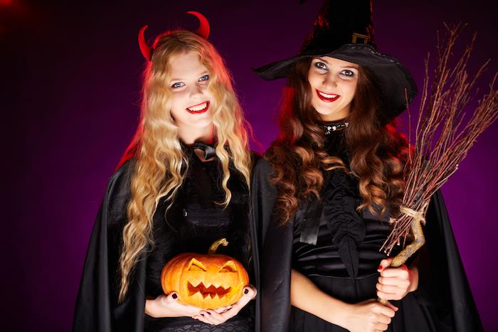 Helovino kostiumo moterims pavyzdys, ragana, apsiaustas ir juoda suknelė, velnio ragai, moliūgų žibintas, šluota