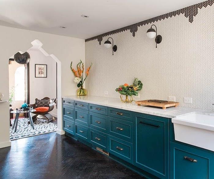 benzininio mėlyno atspalvio virtuvės fasado, pilkos anglies pilkos spalvos parketo, marmurinio stalviršio ir geometrinio rašto sienos idėja