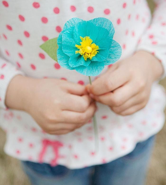 mavi yaprakları ve sarı kalp ve yeşil tel sapı ile basit bir krepon kağıt çiçek örneği