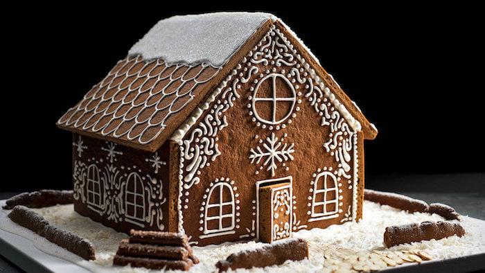 macun duvarları ve çatısı olan geleneksel zencefilli kurabiye evi ve kraliyet buzlanma ile dekoratif süslemeler