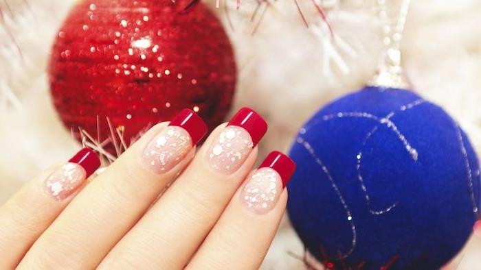 rdeča nohtna umetnost za božič, goli lak za nohte, roza barva, majhne bele pike in rdeči nasveti za nohte, rdeča in modra božična kroglica