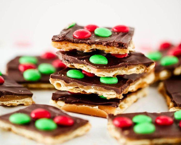 vzorec recepta za božične piškote, prekrit s čokoladno karamelo in rdečimi in zelenimi čokoladnimi žetoni