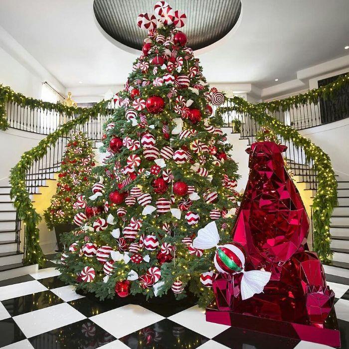 primer rdeče -belega drevesa z okrasjem velikih božičnih kroglic in naravnimi drevesi iz poprove mete ter dekoracijo naravnih stopnic