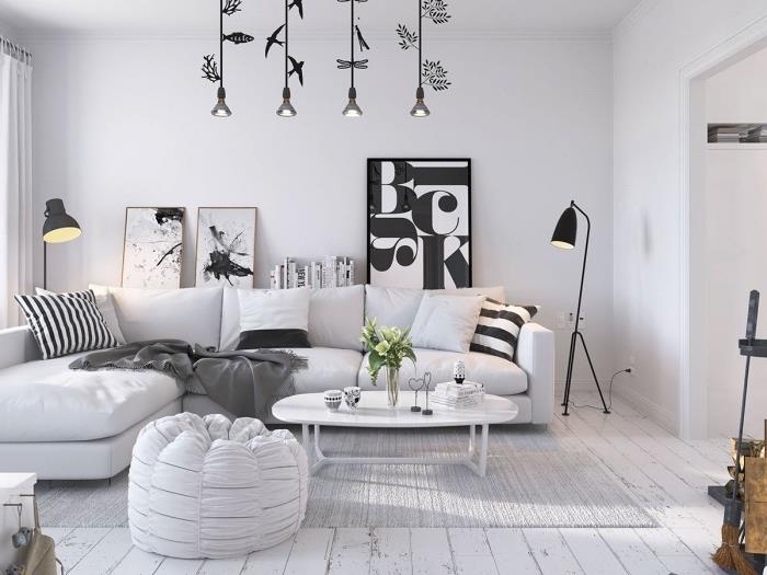 İskandinav oturma odası, gri halı, siyah beyaz dekoratif minderli beyaz kanepe, grafik dekoratif paneller, orijinal sarkıt lambalar nasıl dekore edileceğine dair fikir