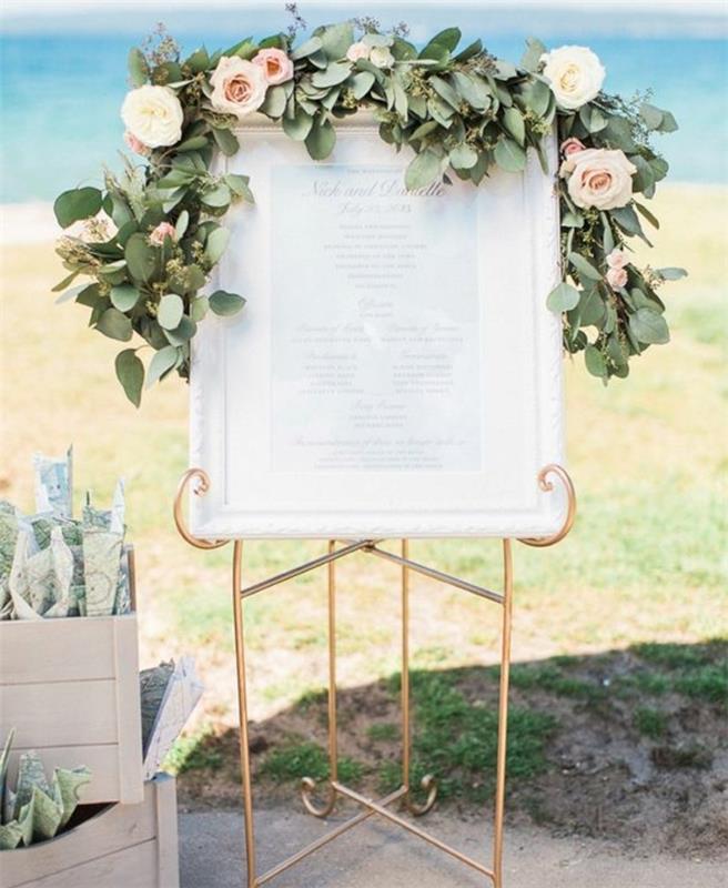 vestuvių stalo planas spausdinti, paprastas sąrašas atspausdintas baltu rėmu, auksinė atrama ir žalia girlianda su rožėmis