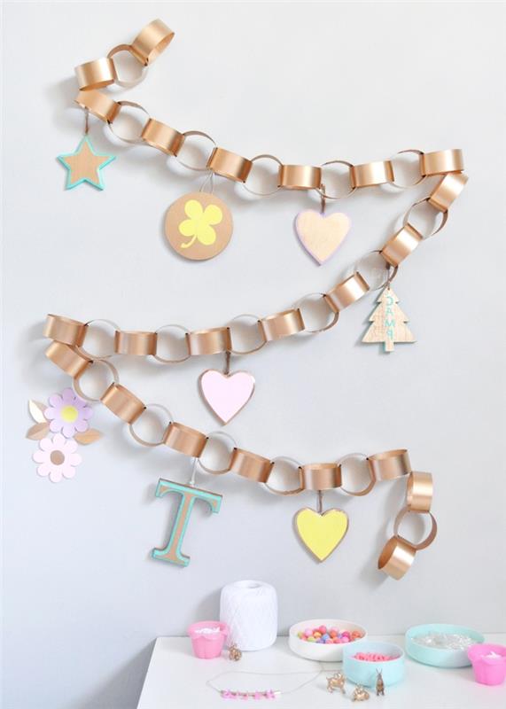 padaryti popierinį Kalėdų deko, žiedų girliandą auksiniais tapetais, dekoruotą pastelinių tonų mediniais ornamentais