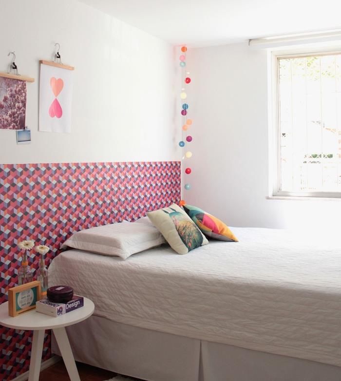 Küçük eski yatak odasına enerji vermek için duvar boyunca yerleştirilmiş, yatağın başucuna güzel grafik duvar kağıdı