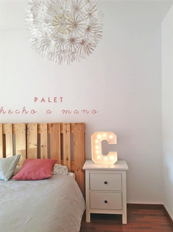 vzglavje palete, bela spalnica z lesenimi tlemi in zakonsko posteljo, okrašeno z rožnatimi in modrimi blazinami