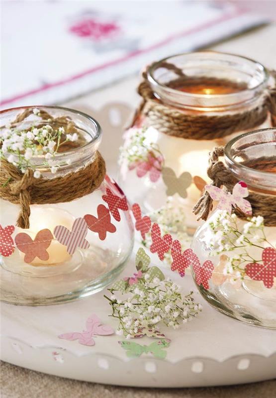 naredite svečnik v steklenem kozarcu, okrašenem z vrvico in vencem iz papirnatih metuljev, sredi pomladi