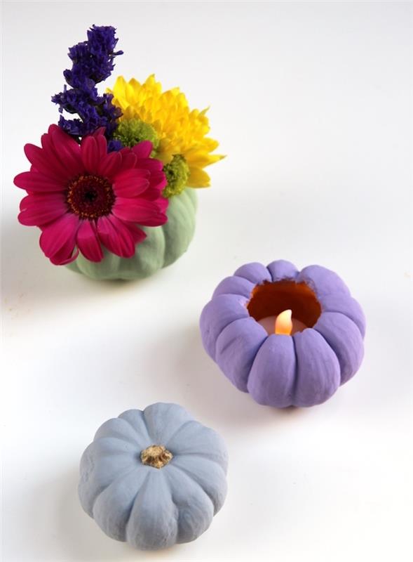 primer enostavne jesenske dekoracije z bučami, okrašenimi z barvo in izpraznjenimi za izdelavo svečnika ali vaze s šopkom rož v notranjosti