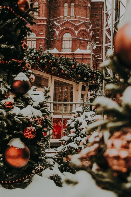 kokie tapetai Kalėdų tapetams, Linksmų Kalėdų 2019 įvaizdis su plytų fasado pastatu ir didelėmis dekoruotomis eglėmis