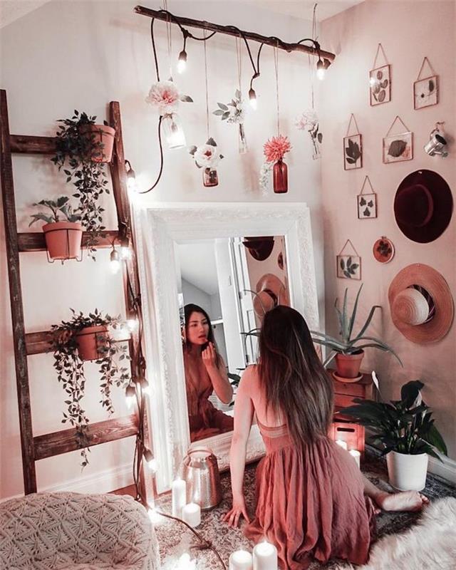 Dekle se gleda v ogledalo in se liči, roza obleka, lestve za shranjevanje cvetja, listi v okvirjih