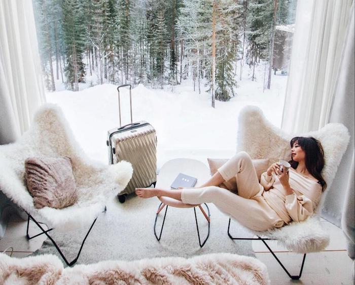 miegamasis su išoriniu stikliniu stogu, jaukus fotelis, kokoniškas moters vaizdas, ilsintis ant skandinaviško fotelio, kokoninis kilimas, vaizdas į snieguotą kalną