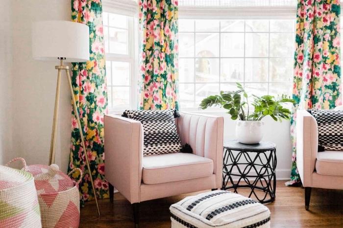 pastel pembe kumaş mobilyalar ve mat siyah vurgularla döşenmiş beyaz duvarlar ve koyu ahşap zemin ile modern oturma odası dekoru