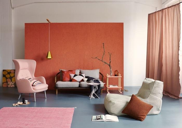 pastelinė rožinė fotelis šviesiai rožinis kilimas terakotos sienų tapyba svetainės dekoravimas ilgos terakotos užuolaidos pilka ir metalinė sofa terakotos pagalvė