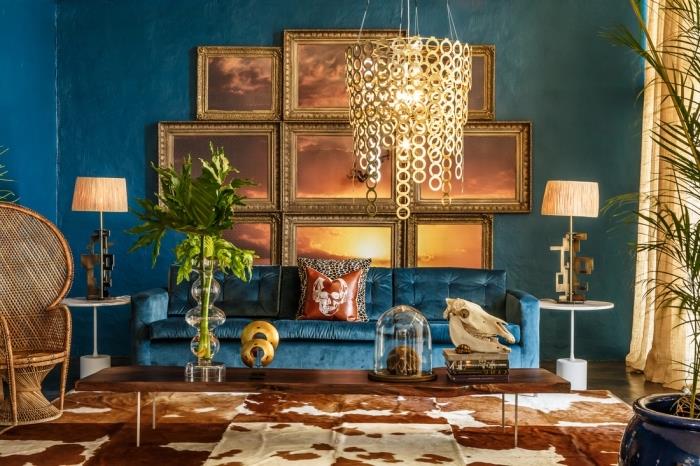 ideja za etnično dekoracijo z račjimi modrimi stenami in steno iz zlatih okvirjev, modeli iz fotelja iz ratana pava