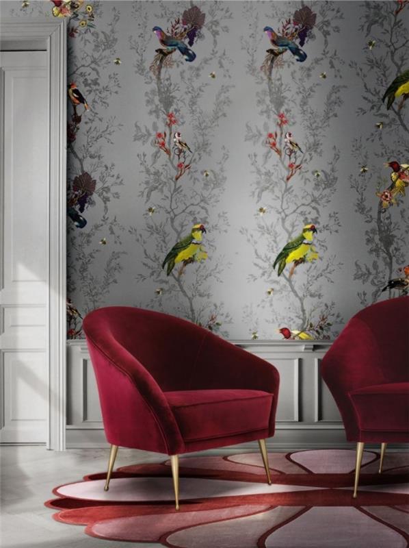 kırmızı kadife mobilyalarla döşenmiş, renkli kuş desenleri ile gri duvar kağıdı duvarları olan bir oturma odasında 2020 deco trendi