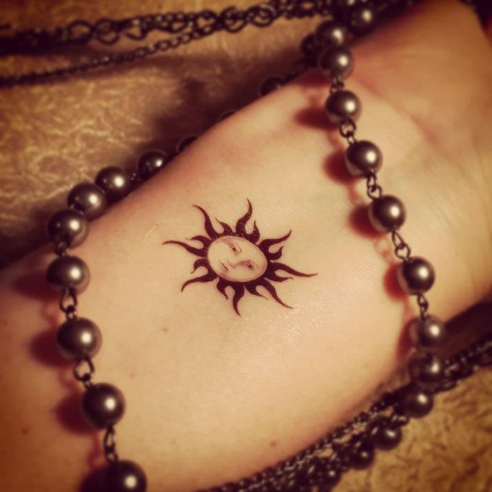 netikra nuolatinė laikinos tatuiruotės idėja maža tatuiruotė moteris ranka saulė