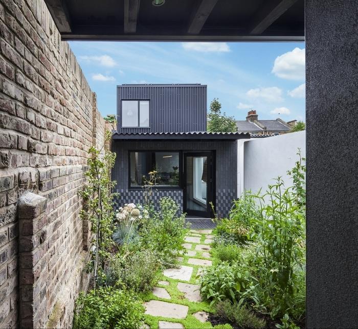 antracito pilkas namas fasadas deko mažas sodas gyvatvorės tvoros plytos gėlės tako plokštės