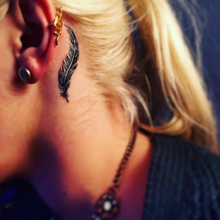 juoda plunksna už metų tatuiruotės, moteris šviesiais plaukais kuoduose, mažos prasmingos tatuiruotės