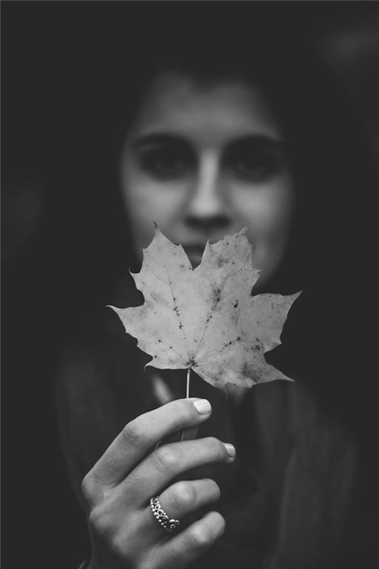 Portretna fotografija dekleta, roka, ki drži jesenski list, grafična fotografija, elegantne črno -bele estetske fotografije