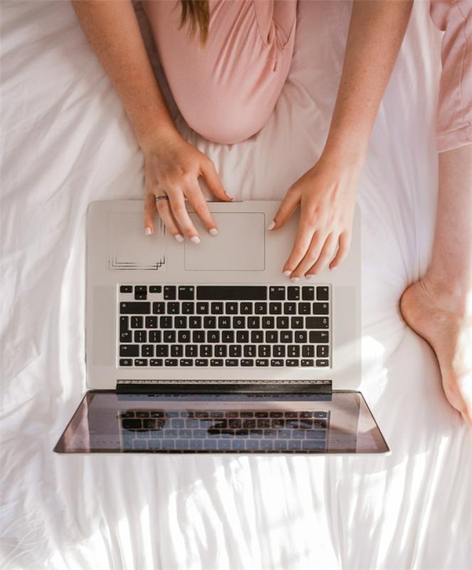 Rankos ant apšviesto nešiojamojo kompiuterio, saugus naršymas internete, moteris lovoje su kompiuteriu, naujienos „BBC News“