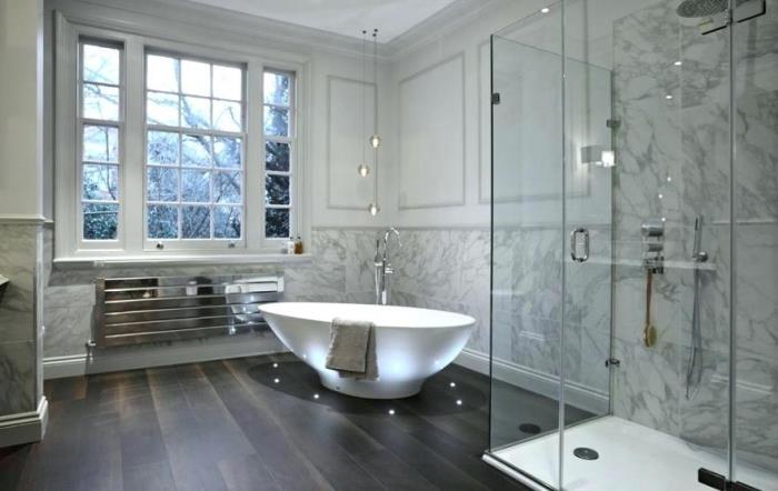 razkošen in prefinjen dizajn v kopalnici s sivimi belimi marmornimi stenami s samostoječo kadjo in led osvetlitvijo na tleh
