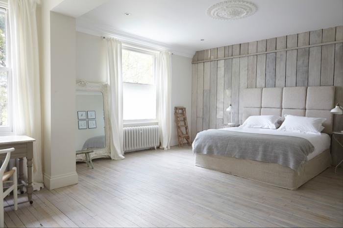 Boş alan ve hafif ahşap mobilyalar ile minimalist tarzda döşenmiş yatak odasında ekru rengi