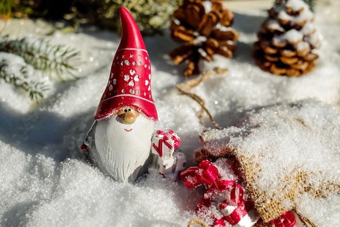 dirbtinio sniego kalėdiniai tapetai su kankorėžiais, spygliuočių šakomis ir Kalėdų Senelio nykštukų figūrėlėmis