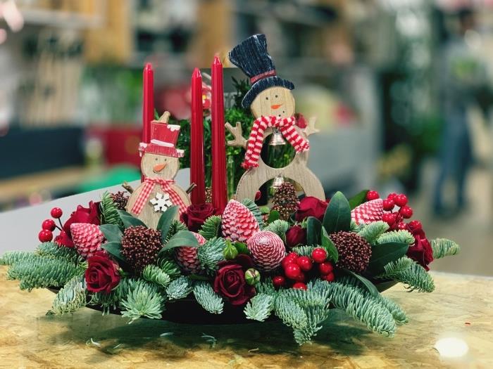 šventinės kompozicijos šablonas iš rožinių eglių šakų ir vaisių, „pasidaryk pats“ kalėdinė kompozicija su žvakėmis ir medinėmis figūrėlėmis