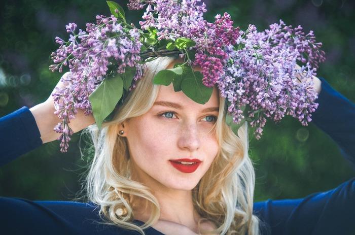 Blondinka, ki nosi spomladanski cvetlični venec, škrlatna šminka, pomladna pokrajina, ozadje in ozadje ženskega portreta