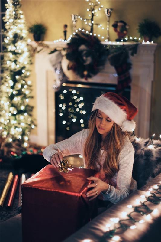 Kalėdinės tematikos išmaniojo telefono ekrano užrakto nuotrauka, linksmas Kalėdų vaizdas su mergina šviesiai dekoruotoje svetainėje